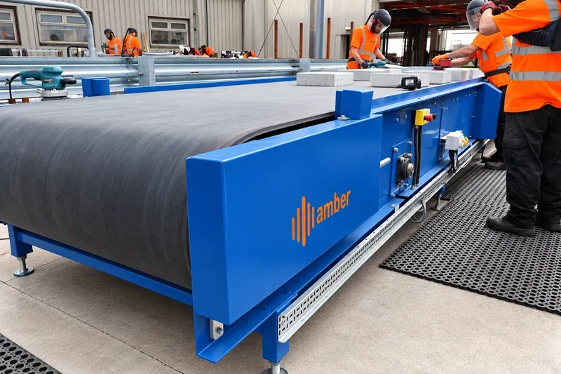 Amber Industries blue belt conveyor system used in street furniture manufacturing